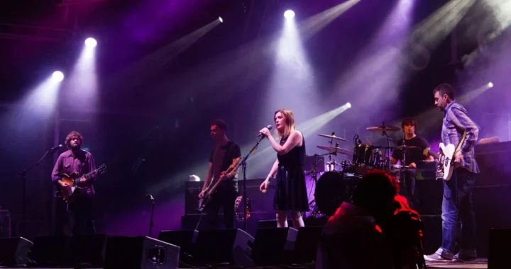 Slowdive performing on a purple-lit festival stage