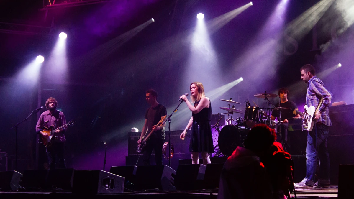 Slowdive performing on a purple-lit festival stage