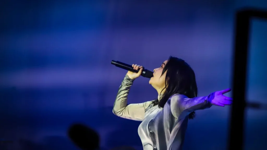 Mitski sings with her arm outstretched at the Royal Albert Hall in London