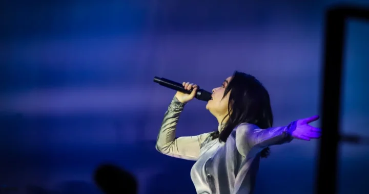 Mitski sings with her arm outstretched at the Royal Albert Hall in London