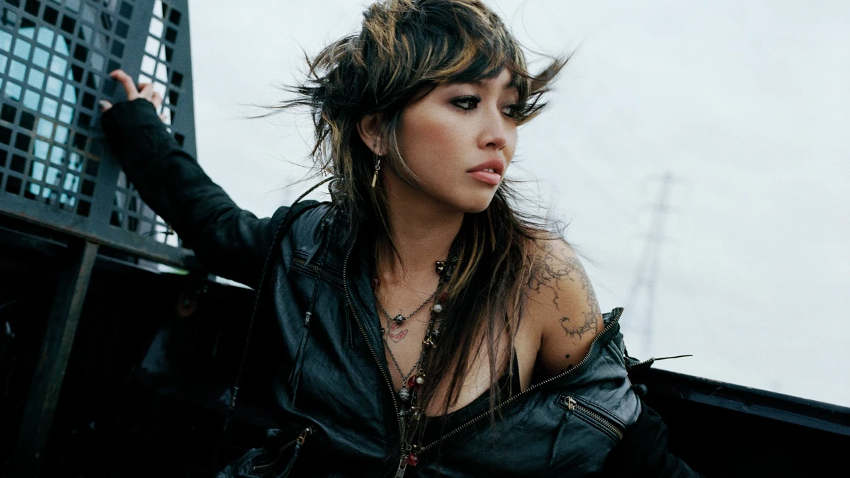 Beabadoobee in a Pylon-era press photo with an electricity pylon behind her